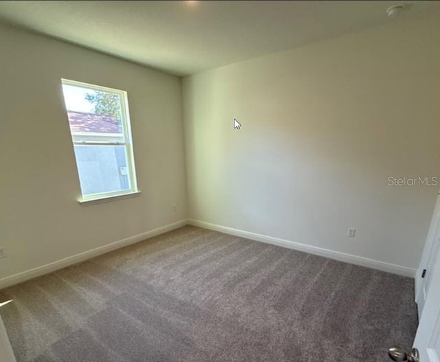 unfurnished room featuring baseboards and carpet flooring