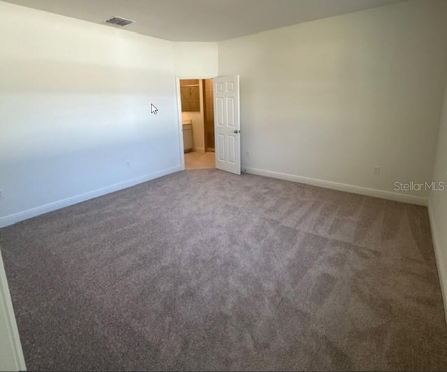 spare room with visible vents, baseboards, and light colored carpet