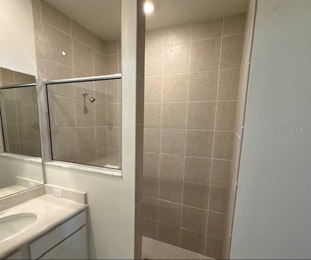 bathroom with vanity and tiled shower