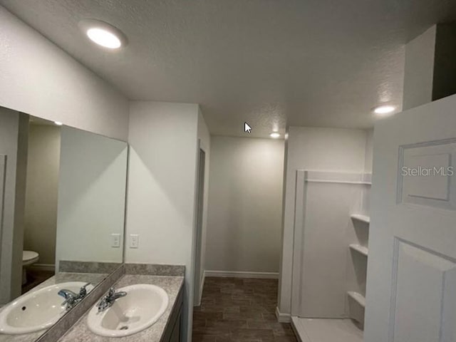 bathroom featuring vanity, toilet, and a textured ceiling