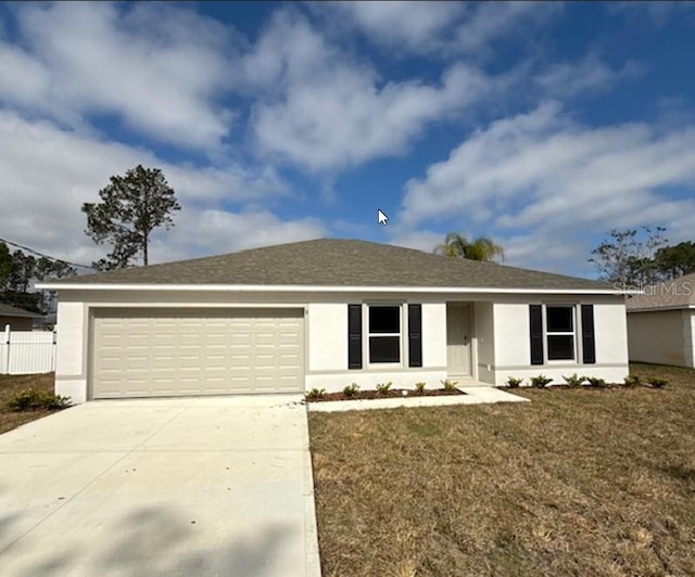 single story home featuring a garage and a front lawn