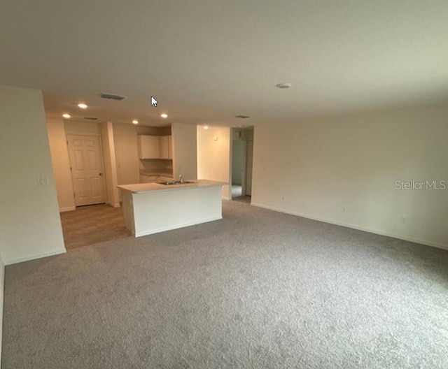 unfurnished living room with light colored carpet