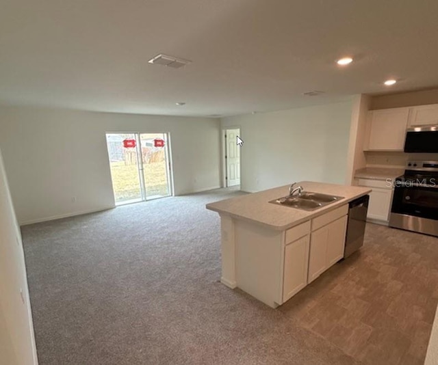 kitchen featuring sink, white cabinetry, a center island with sink, appliances with stainless steel finishes, and light colored carpet