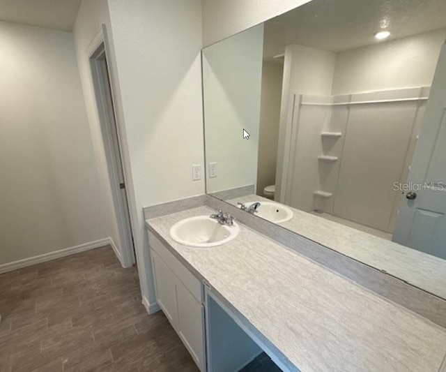 bathroom featuring wood-type flooring, toilet, and vanity