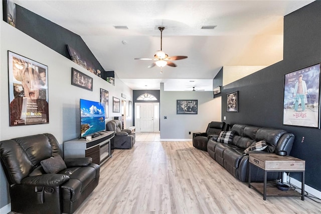 living room featuring lofted ceiling, ceiling fan, and light hardwood / wood-style flooring