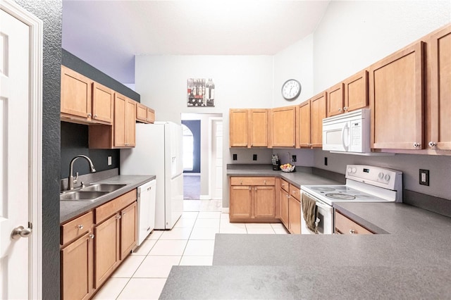 kitchen featuring white appliances, a towering ceiling, sink, and light tile patterned floors