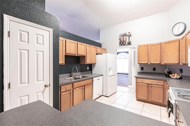 kitchen with white appliances, a towering ceiling, sink, and light tile patterned floors