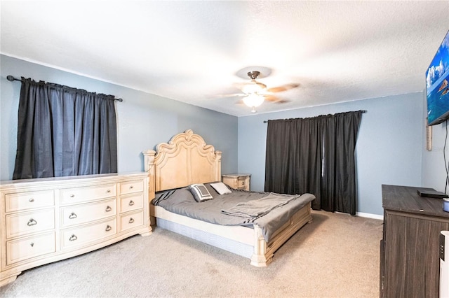 bedroom with light colored carpet, a textured ceiling, and ceiling fan