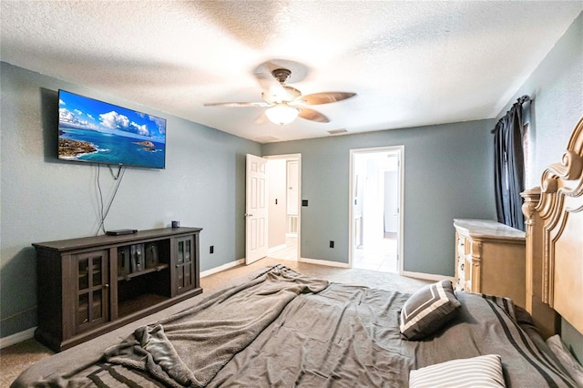 bedroom featuring a textured ceiling, light colored carpet, and ceiling fan