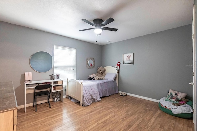 bedroom with ceiling fan and light hardwood / wood-style floors