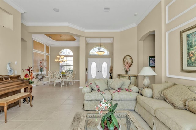 tiled living room with a notable chandelier, crown molding, and french doors