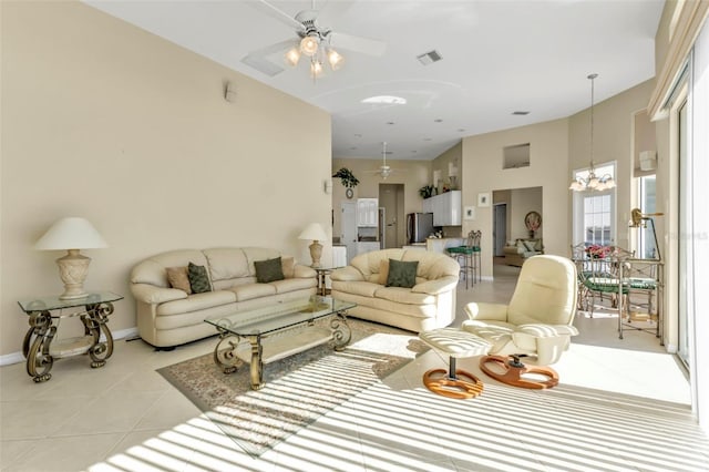 tiled living room featuring ceiling fan with notable chandelier