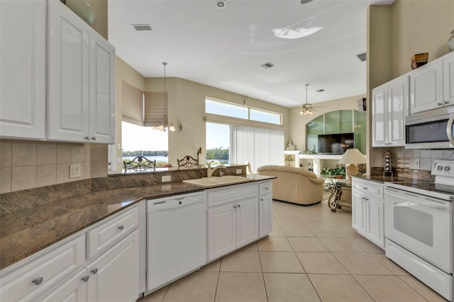 kitchen featuring white cabinetry, sink, hanging light fixtures, light tile patterned floors, and white appliances