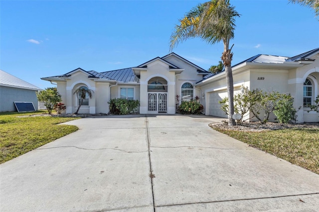 ranch-style home with french doors, a garage, and a front yard