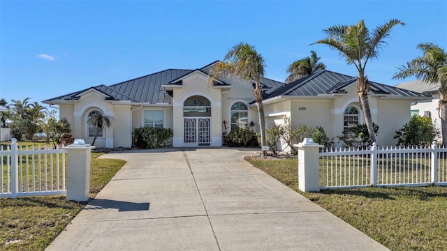 view of front facade with a garage, a front lawn, and french doors