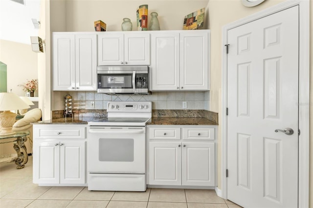 kitchen with electric stove, white cabinetry, light tile patterned flooring, and backsplash