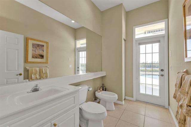 bathroom featuring a bidet, tile patterned floors, toilet, and vanity