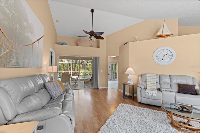 living room with hardwood / wood-style flooring, high vaulted ceiling, and ceiling fan