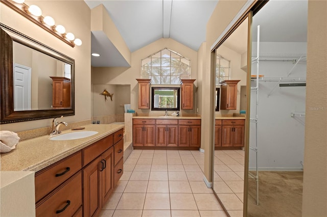 bathroom featuring vanity, vaulted ceiling, and tile patterned floors