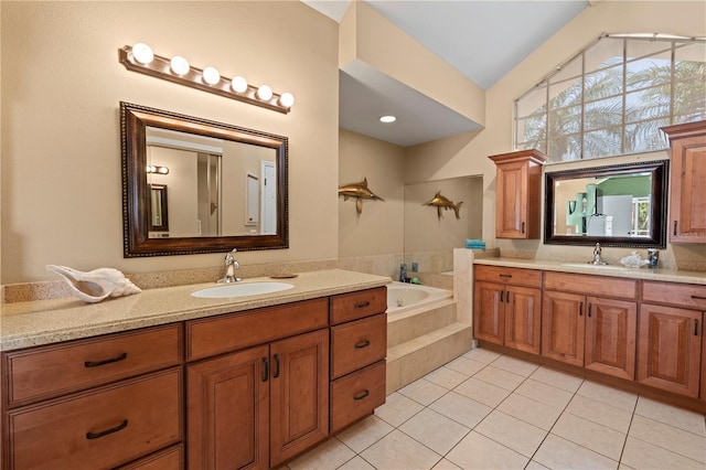 bathroom with tile patterned floors, vaulted ceiling, vanity, and tiled tub