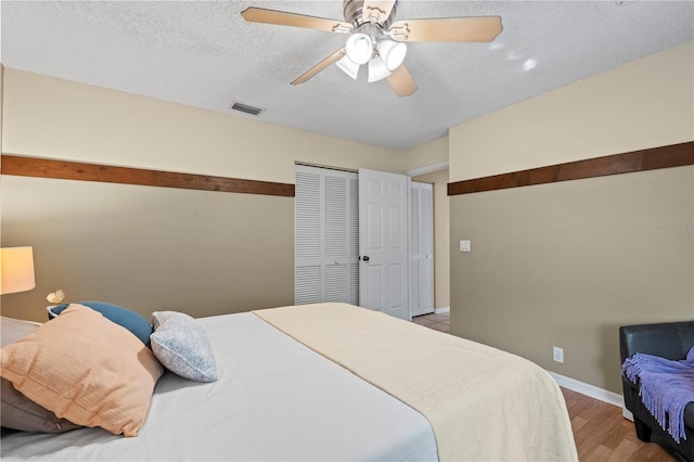 bedroom featuring ceiling fan, hardwood / wood-style floors, a textured ceiling, and a closet