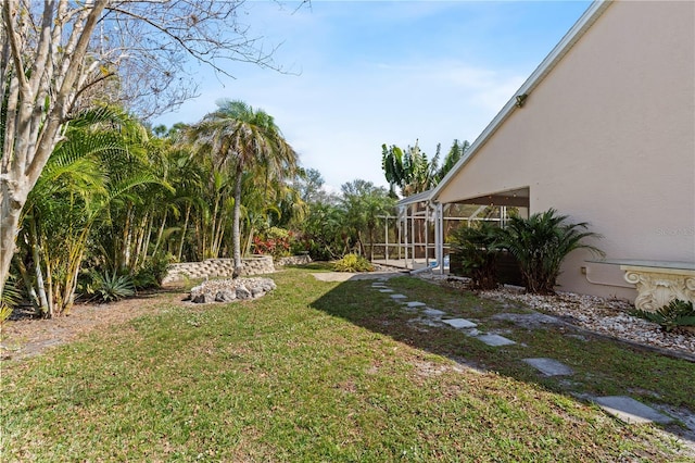 view of yard with glass enclosure