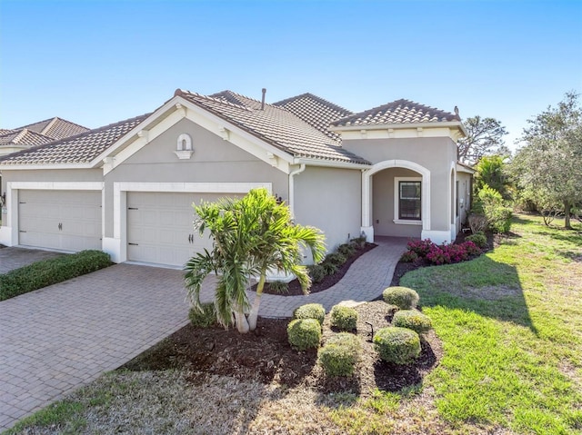 mediterranean / spanish house with a garage and a front yard