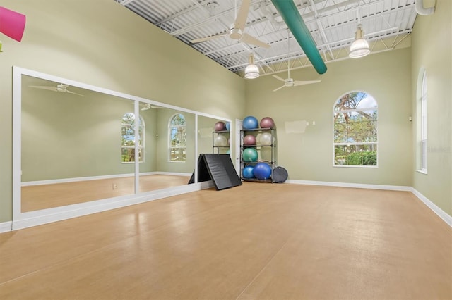 workout area with ceiling fan and a high ceiling