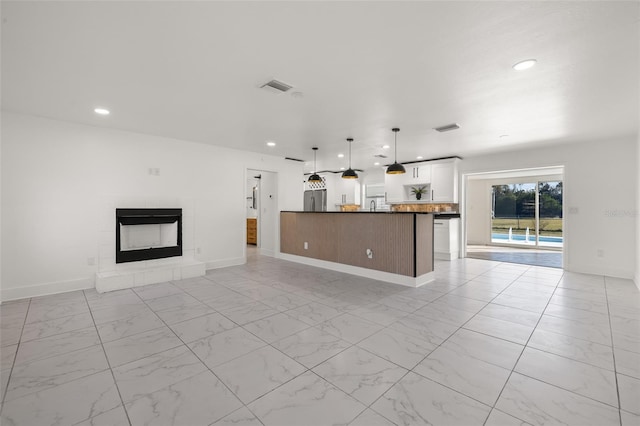 unfurnished living room featuring a tiled fireplace