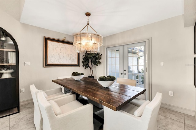 dining space featuring french doors and a notable chandelier