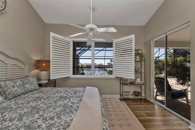 bedroom with multiple windows, access to outside, dark hardwood / wood-style floors, and vaulted ceiling