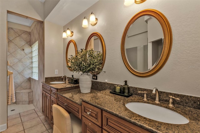 bathroom featuring vanity, tile patterned floors, and a tile shower