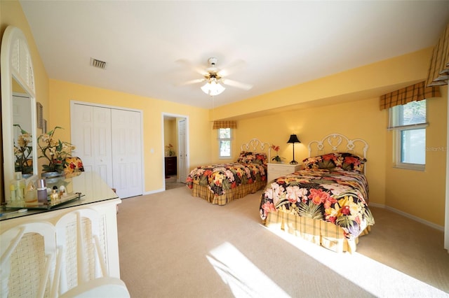 carpeted bedroom featuring ceiling fan and a closet