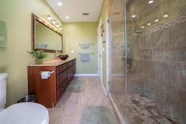 bathroom featuring vanity, toilet, and a shower with door