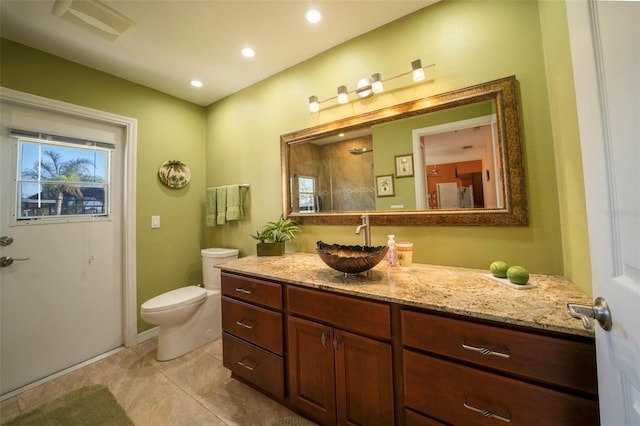 bathroom with tile patterned flooring, vanity, a shower, and toilet