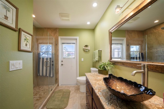 bathroom with vanity, an enclosed shower, plenty of natural light, and toilet