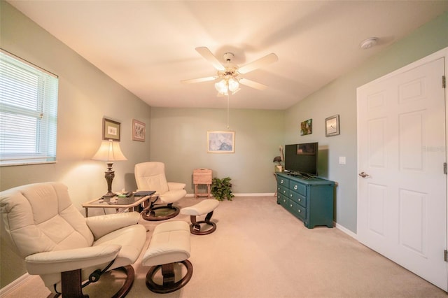 living area with light carpet and ceiling fan