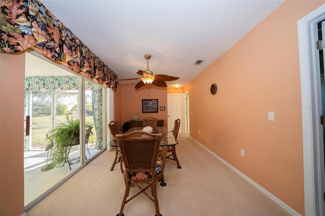 carpeted dining area with ceiling fan