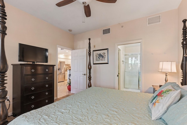 tiled bedroom featuring high end refrigerator, connected bathroom, and ceiling fan