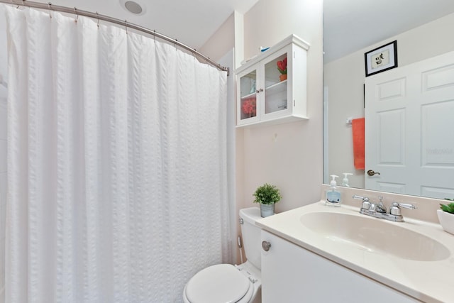 bathroom featuring vanity, toilet, and walk in shower