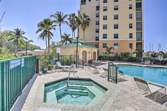 view of pool with a hot tub and a patio