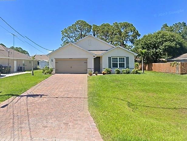 ranch-style house featuring a garage and a front lawn