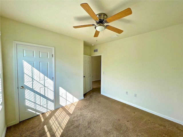 carpeted spare room with ceiling fan