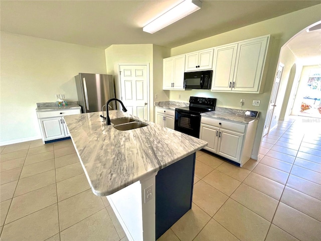 kitchen with white cabinetry, an island with sink, sink, light tile patterned floors, and black appliances