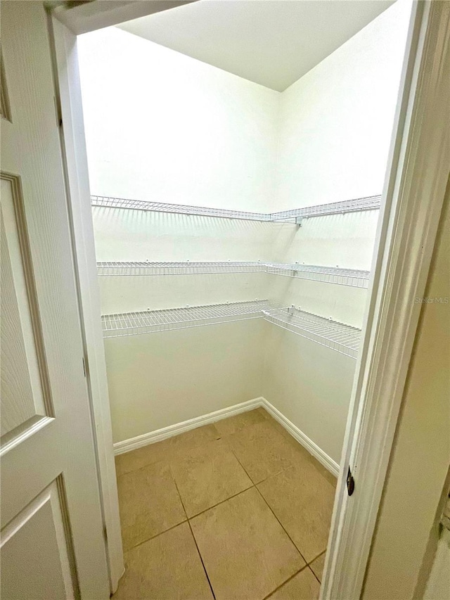 spacious closet with light tile patterned floors