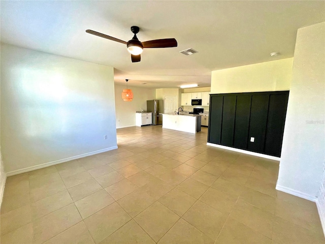 unfurnished living room with light tile patterned floors and ceiling fan