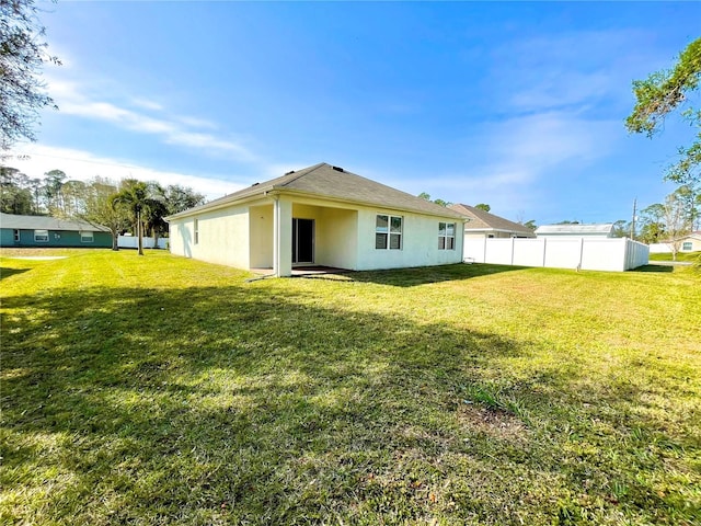 rear view of house featuring a lawn