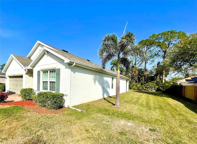 view of home's exterior with a garage and a yard