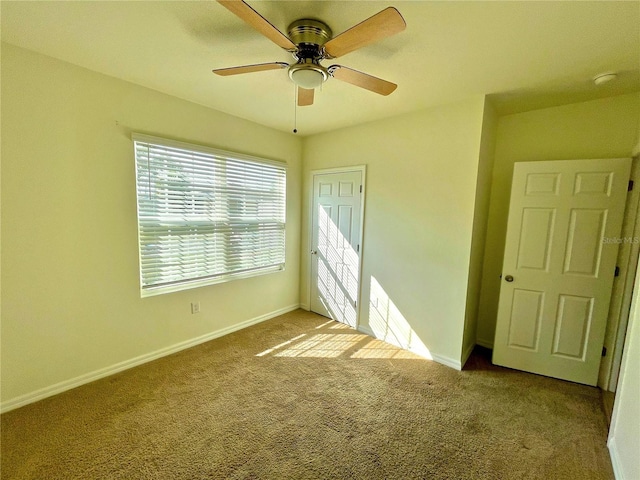 empty room with ceiling fan and light carpet