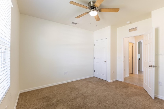 unfurnished bedroom with light carpet and ceiling fan